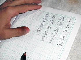 男性がノートで練習している漢字＝兵庫県内