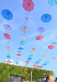 太陽の光を受け、夏空に映える色とりどりの傘＝淡路市夢舞台、明石海峡公園（撮影・坂井萌香）