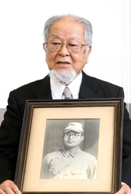 父三郎さんの遺影を抱いて語る三木英一さん＝姫路市本町（撮影・辰巳直之）