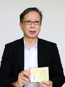祖父の記録を手に「祖父や多くの人の無念を風化させたくない」と話す荒堀修一さん＝神戸市中央区