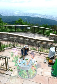 開放的な展望台でチョーク画の仕上げを行う作家の松本かなこ氏＝神戸市灘区六甲山町（撮影・中西幸大）
