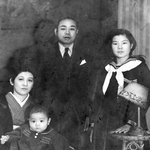 嘉数さん一家。中央が父の昇さん、左が母の千代子さんと幼少時代の昇明さん、右が姉