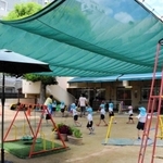 遮光ネットの下で遊ぶ園児たち＝神戸市長田区神楽町２、神楽こども園