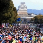 世界文化遺産・国宝姫路城を背に一斉にスタートするランナーら＝２０１９年２月、姫路市内