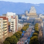 姫路城を背に一斉にスタートするランナーたち＝２０１９年２月、姫路市内