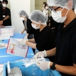 袋詰めした抗原検査キットを検品するスタッフ＝５日午前、明石市本町１