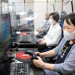シニア専用ｅスポーツ施設で熱中する利用者ら＝神戸市中央区古湊通１