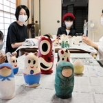 ロシア出身の夫を持つ平野陽子さん（左から２人目）らが企画した「国境なきマトリョーシカ展」に向け、マトリョーシカに絵付けをする画家ら＝神戸市兵庫区五宮町