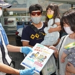 神戸淡路鳴門自動車道の淡路サービスエリアで利用客に安全運転を呼びかける警察官（左）＝淡路市岩屋