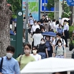 盆が明け、厳しい残暑の中、出勤する人たち＝１６日朝、神戸市中央区
