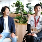 東京パラリンピックの銀メダルなどを首に掛け、Ｄ２Ｃのグループ本社を訪れた大矢勇気（右）。隣が採用を担当した青沼邦之さん＝５月１８日、東京都港区（同社提供）