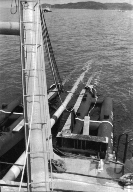 敷設船上で溶接され、船尾から次々と海底に沈められるパイプ＝１９８３（昭和５８）年４月８日、飾磨郡（姫路市）家島沖、油島丸船上