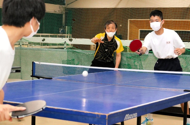 播磨中の体育館で卓球部員を指導する井下原哲生さん（中央）＝５月、兵庫県播磨町南大中１