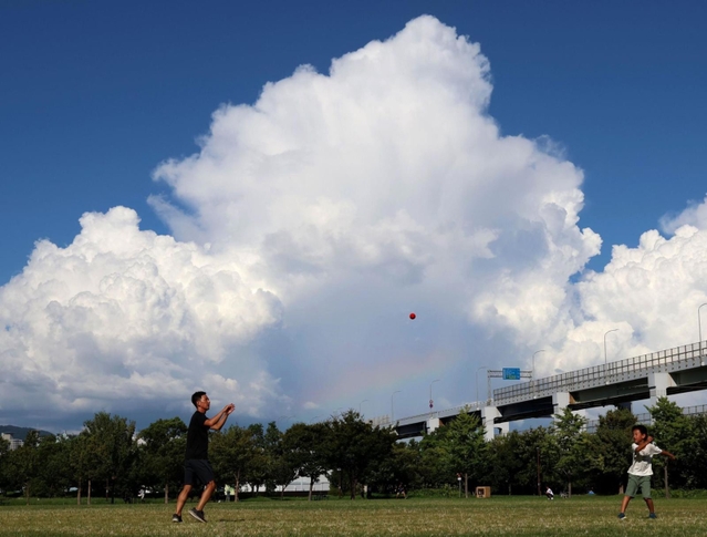 沸き上がる入道雲。刻々と姿を変える中、小さな虹（中央）が現れた＝４日午後、神戸市中央区小野浜町、みなとのもり公園