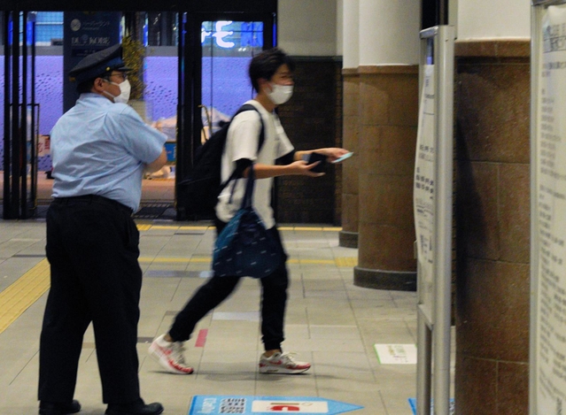 最終電車が発車する間際に改札へ駆け込む利用客と、誘導する駅員＝１９日午後５時３０分、ＪＲ神戸駅