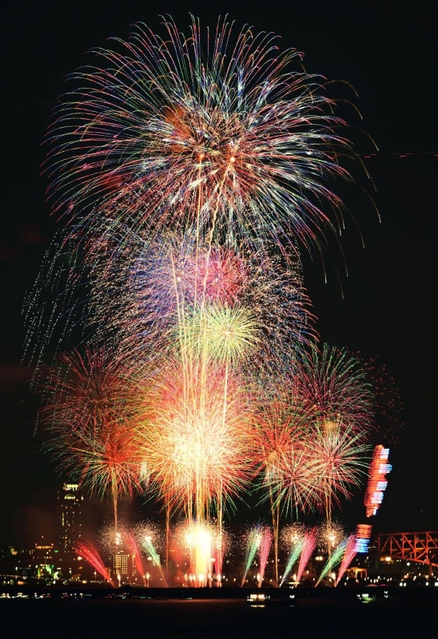 大阪・夢洲エリアの夜空に打ち上がった色とりどりの花火＝２５日夜、神戸市中央区東川崎町１から（写真５枚を比較明合成、超望遠レンズで撮影）