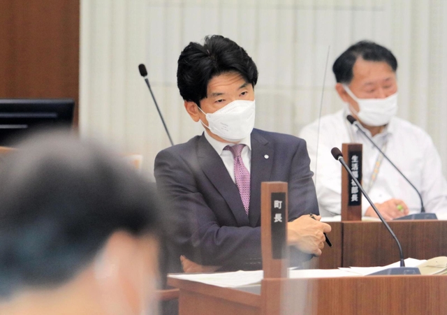 不信任決議案が提出され、各議員の討論を厳しい表情で聞く服部千秋町長＝２６日午後、兵庫県太子町鵤、町議会議場