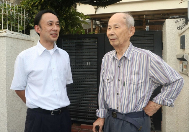 神戸の華僑の支援を続ける石嘉成さん（右）、鋒さん親子＝神戸市長田区