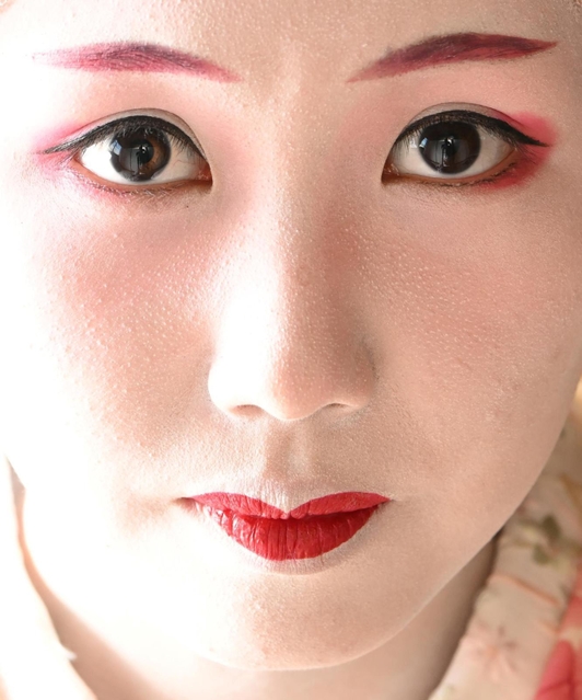 先端が細い「笹眉」を塗るなど伝統の化粧を自ら行うさくらさん。優美な表情から心根の強さも伝わってくる＝神戸市北区有馬町