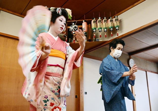 有馬検番の代表、一七四さん（右）はこの道約半世紀のベテラン。踊りの確認を受ける時、稽古場に緊張感がみなぎる＝神戸市北区有馬町