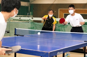 播磨中の体育館で卓球部員を指導する井下原哲生さん（中央）＝５月、兵庫県播磨町南大中１