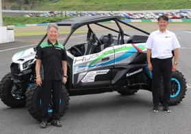 二輪車用の水素エンジンを積んだオフロード四輪車の前で笑顔の川崎重工業の橋本康彦社長（左）ら＝３日午後、栃木県茂木町（撮影・大島光貴）