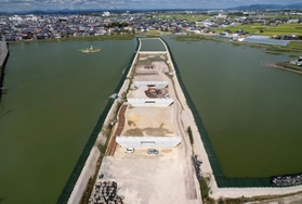 天満大池に橋を架けるため、造成された作業場所。池を割って北へ延びる＝兵庫県稲美町（ドローンで撮影）