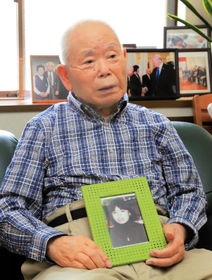 拉致被害に遭った娘の有本恵子さんの写真を抱え、日朝首脳会談当時を振り返る明弘さん＝神戸市長田区