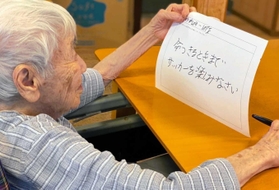メッセージをしたためる竹本繁野さん（オリンピア兵庫提供）