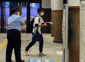 最終電車が発車する間際に改札へ駆け込む利用客と、誘導する駅員＝１９日午後５時３０分、ＪＲ神戸駅