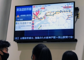 改札の前で列車の遅延や運休の情報を確かめる利用客たち＝１９日午後３時２９分、ＪＲ神戸駅