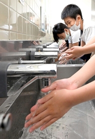センサー式の自動水栓に手を伸ばす小学生ら＝西須磨小学校（撮影・秋山亮太）