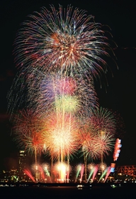 大阪・夢洲エリアの夜空に打ち上がった色とりどりの花火＝２５日夜、神戸市中央区東川崎町１から（写真５枚を比較明合成、超望遠レンズで撮影）