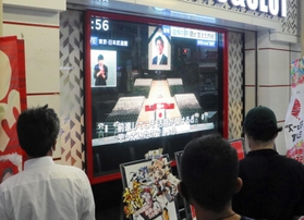 足を止め、安倍氏国葬のテレビ中継を見守る通行人＝２７日午後、神戸市中央区琴ノ緒町５