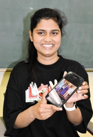 アルバイトで学費を稼ぎ、国際文化を学ぶスリランカ出身のマリンディ・リヤナゲさん。スマートフォンの写真を見ながら家族の思い出を話し始めると、顔がほころんだ＝神戸市北区