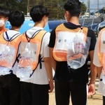 訓練でリュック型の給水袋を背負った負傷者役の大学生ら＝４日午前、兵庫県多可町中区岸上、町立中央公園（撮影・鈴木雅之）