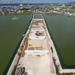天満大池に橋を架けるため、造成された作業場所。池を割って北へ延びる＝兵庫県稲美町（ドローンで撮影）
