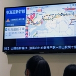 改札の前で列車の遅延や運休の情報を確かめる利用客たち＝１９日午後３時２９分、ＪＲ神戸駅