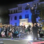 「豊岡演劇祭２０２２」の最終日。路上パフォーマンスを観覧する市民ら＝２５日夜、豊岡市役所前