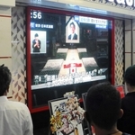 足を止め、安倍氏国葬のテレビ中継を見守る通行人＝２７日午後、神戸市中央区琴ノ緒町５