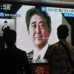 足を止め、安倍氏国葬のテレビ中継を見守る通行人＝２７日午後、神戸市中央区琴ノ緒町５