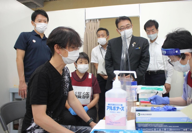 接種会場を視察する斎藤元彦知事（左）＝１日午後、姫路市日出町３