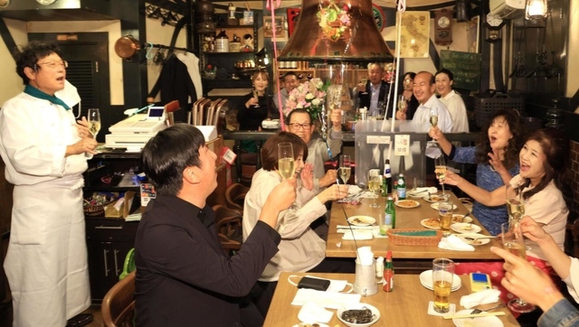 村上春樹さんのノーベル文学賞を願い「来年こそは」と乾杯する店のオーナー山中崇裕さん（左端）とハルキストら＝６日夜、神戸市中央区中山手通２、ピノッキオ（撮影・吉田敦史）