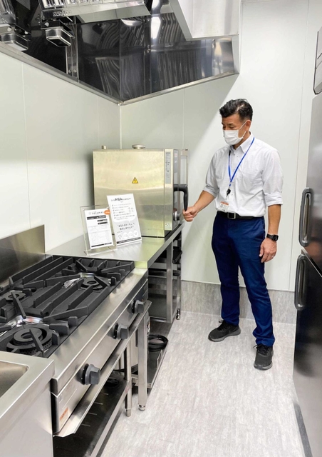 ゴーストキッチンの設備を紹介する瀬尾直弥さん＝丸五商会