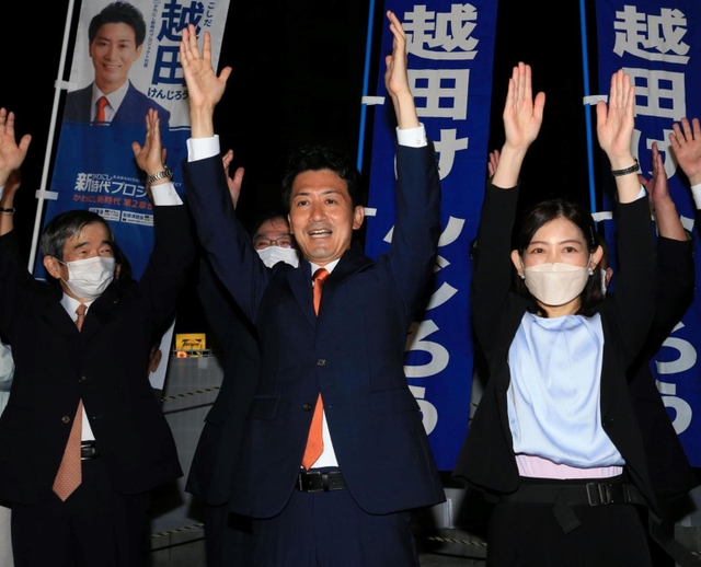 再選を確実にし、支援者らと万歳する越田謙治郎氏。伊丹市の藤原保幸市長（左）らも祝福に駆け付けた＝川西市小戸１（撮影・斎藤雅志）