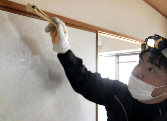 はけを使ってふすまの隙間に薬剤を塗り込む駆除スタッフ＝神戸市内