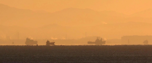 空気の揺らぎで宙に浮かんで見える船＝２６日早朝、神戸市須磨区から（撮影・吉田敦史）