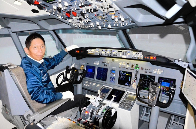 ボーイング７３７のフライトシミュレーターに座る伊藤世一社長。この操縦席で、朝ドラ「舞いあがれ！」第１話の冒頭シーンが撮影された＝神戸市長田区神楽町２、「テクノバード」