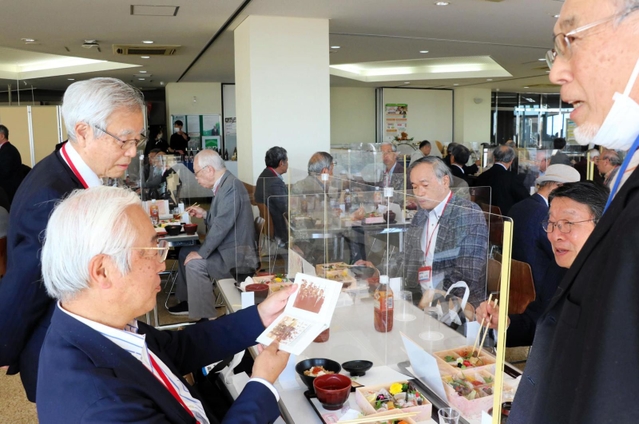 学生当時の写真を見ながら思い出話に花を咲かせる神戸大ＯＢら＝神戸市灘区六甲台町、神戸大六甲第１キャンパス