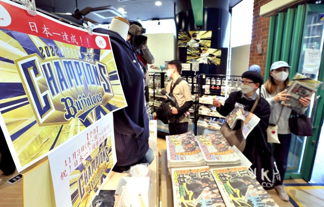 オリックスの球団直営店で、日本一を伝えるスポーツ紙などを買い求めるファンら＝３１日午前、神戸市中央区三宮町１、Ｂ－ＷＡＶＥ（撮影・長嶺麻子）